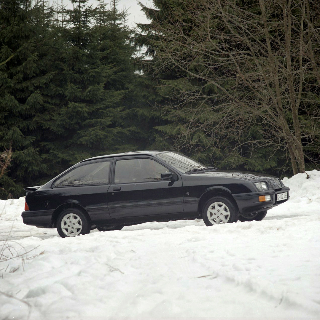 This archival image documents the 1985 Ford Sierra XR 4x4 LHD side view on snowy road with trees and is preserved in the Ford Heritage Vault as part of Ford Motor Company's historic photographic archive. Free for personal, non-commercial use. Ford...