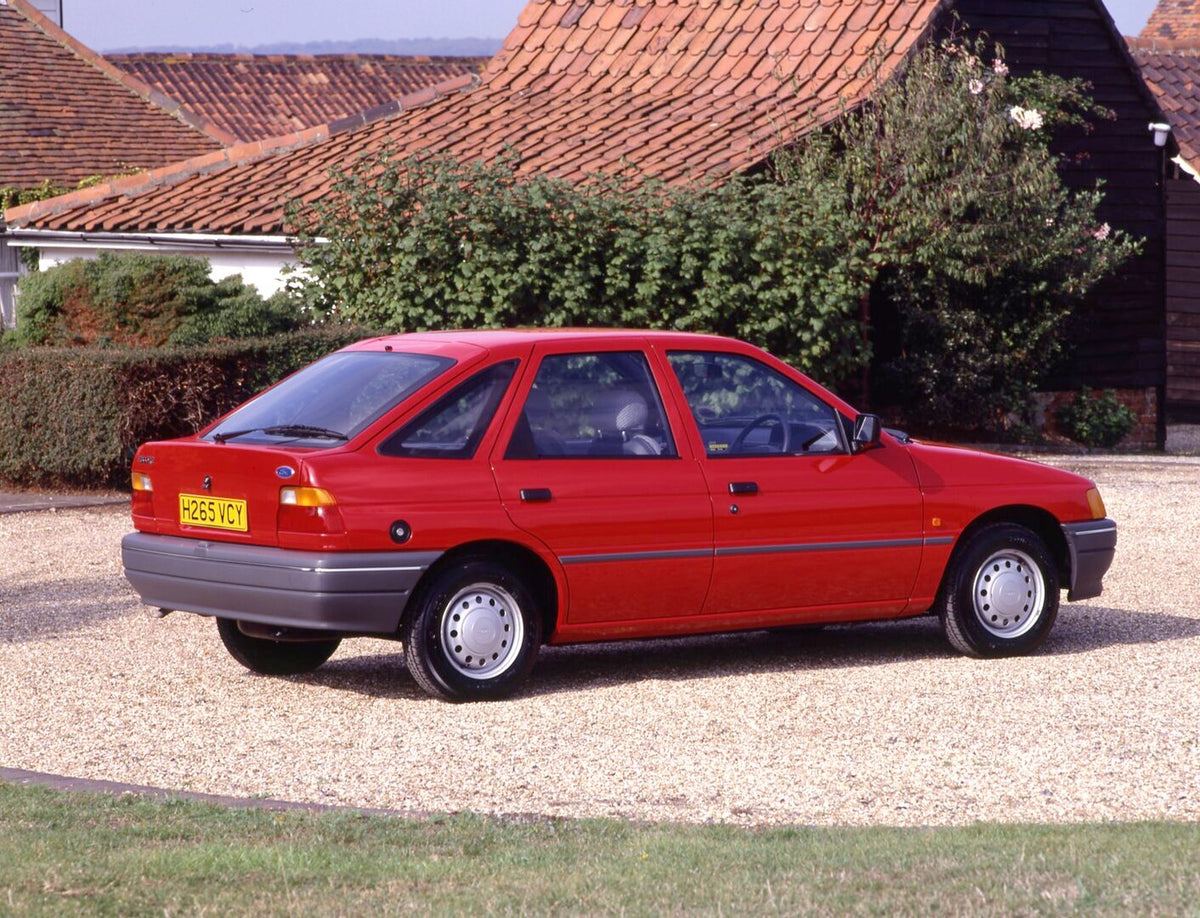 This archival image documents the 1990 Ford Escort Mark V Popular rear view on scenic gravel road and is preserved in the Ford Heritage Vault as part of Ford Motor Company's historic photographic archive. Free for personal, non-commercial use. For...