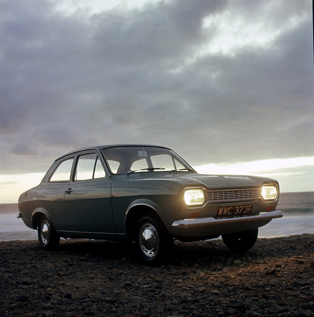 This archival image documents the 1967 Ford Escort Mark I Super and Deluxe with headlights on at beach and is preserved in the Ford Heritage Vault as part of Ford Motor Company's historic photographic archive. Free for personal, non-commercial use...