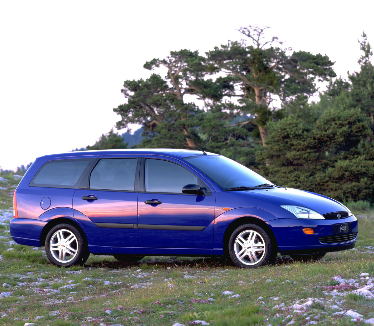 This archival image documents the 1998 Ford Focus side view with scenic trees and is preserved in the Ford Heritage Vault as part of Ford Motor Company's historic photographic archive. Free for personal, non-commercial use. Ford Heritage Vault ref...
