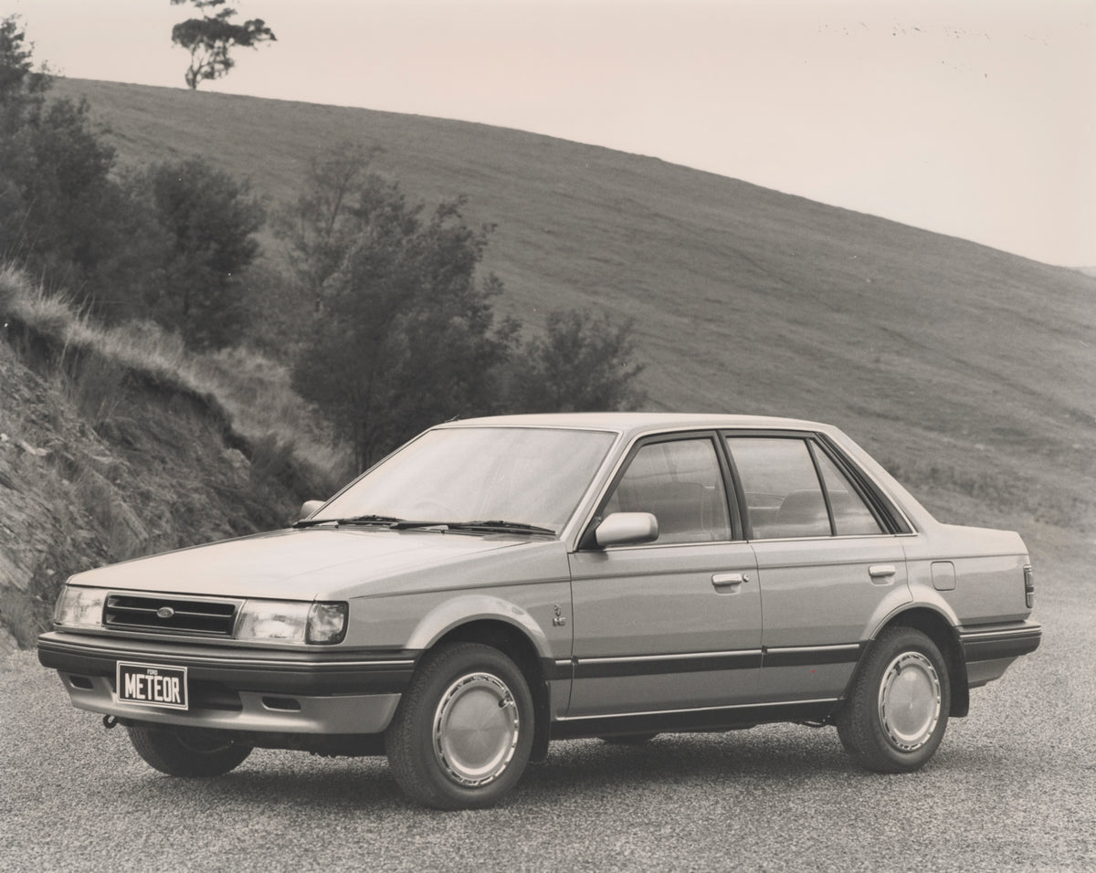 This archival image documents the 1985 Ford GC Meteor Ghia Sedan Passenger Side Front End View on Country Road FAP-2011-3 and is preserved in the Ford Heritage Vault as part of Ford Motor Company's historic photographic archive. Free for personal,...