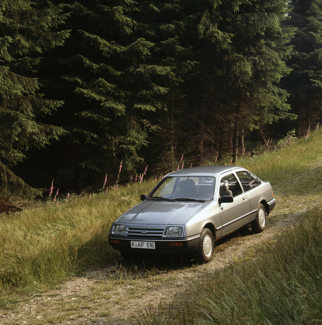 This archival image documents the 1983 Ford Sierra Mark I L aerial view on scenic road with trees and is preserved in the Ford Heritage Vault as part of Ford Motor Company's historic photographic archive. Free for personal, non-commercial use. For...