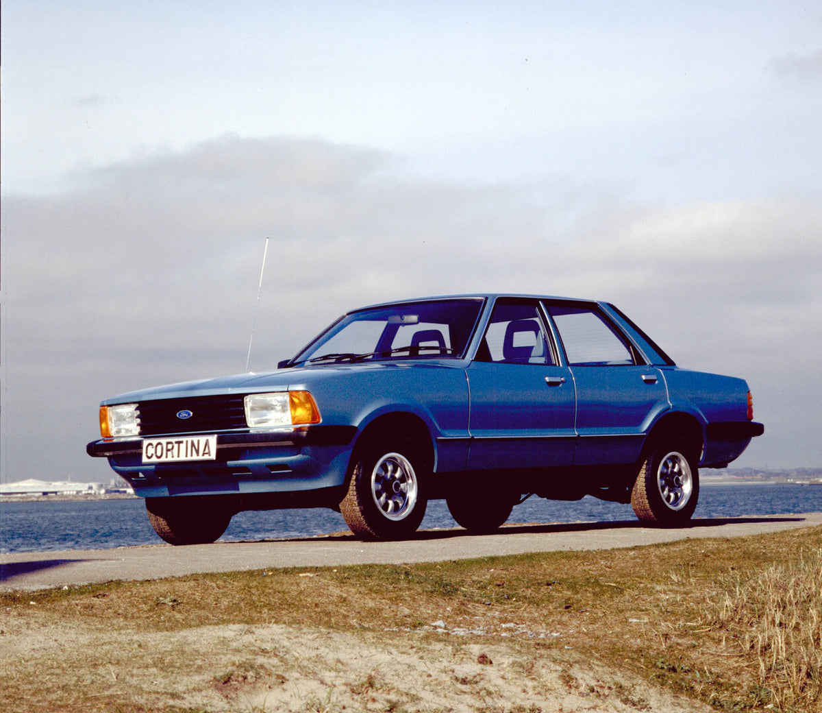 This archival image documents the 1980 Ford Cortina 1.6L MK V in front of water and is preserved in the Ford Heritage Vault as part of Ford Motor Company's historic photographic archive. Free for personal, non-commercial use. Ford Heritage Vault r...