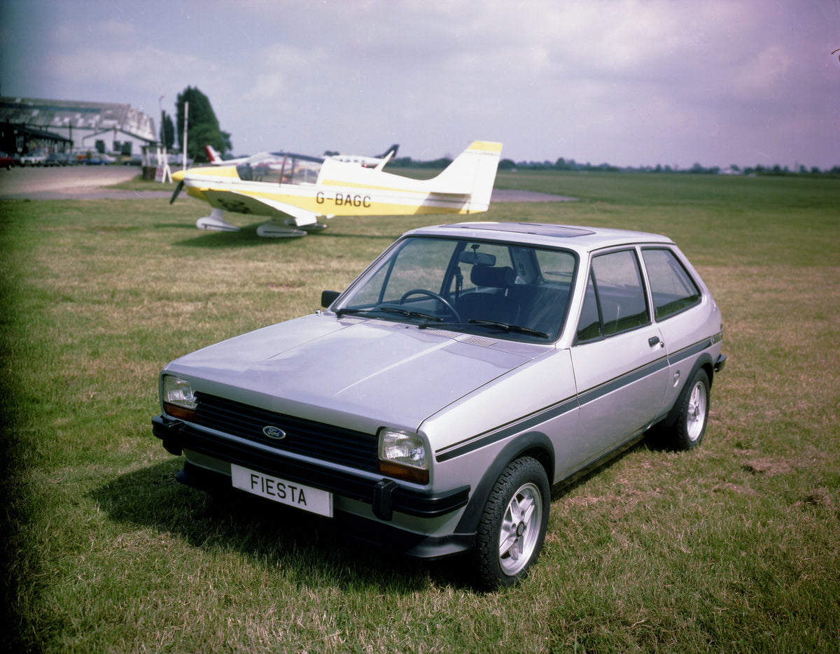 This archival image documents the 1981 Ford Fiesta Mark I X in scenic field with plane and is preserved in the Ford Heritage Vault as part of Ford Motor Company's historic photographic archive. Free for personal, non-commercial use. Ford Heritage ...