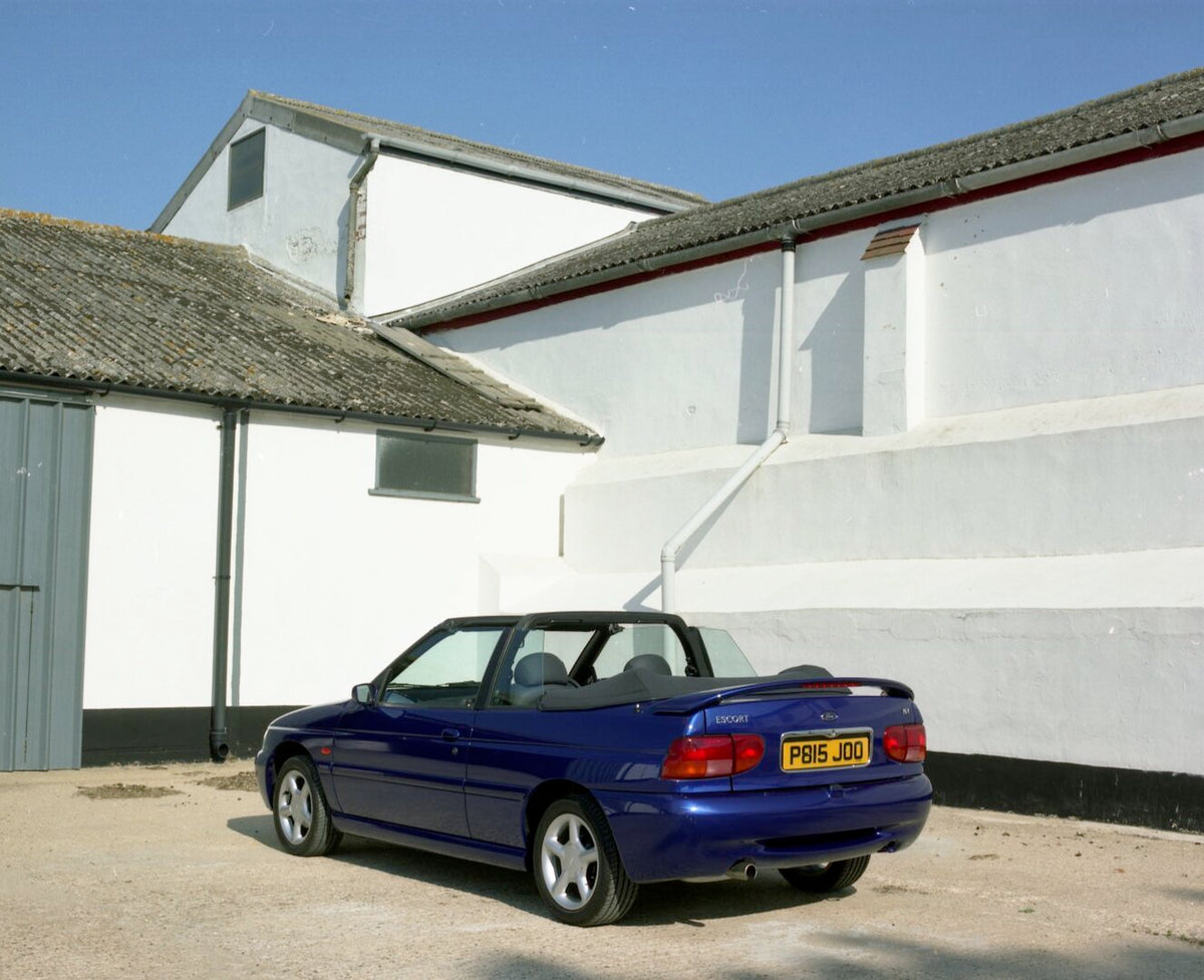 This archival image documents the 1996 Ford Escort Mark VI Cabriolet Ghia rear view in front of building and is preserved in the Ford Heritage Vault as part of Ford Motor Company's historic photographic archive. Free for personal, non-commercial u...