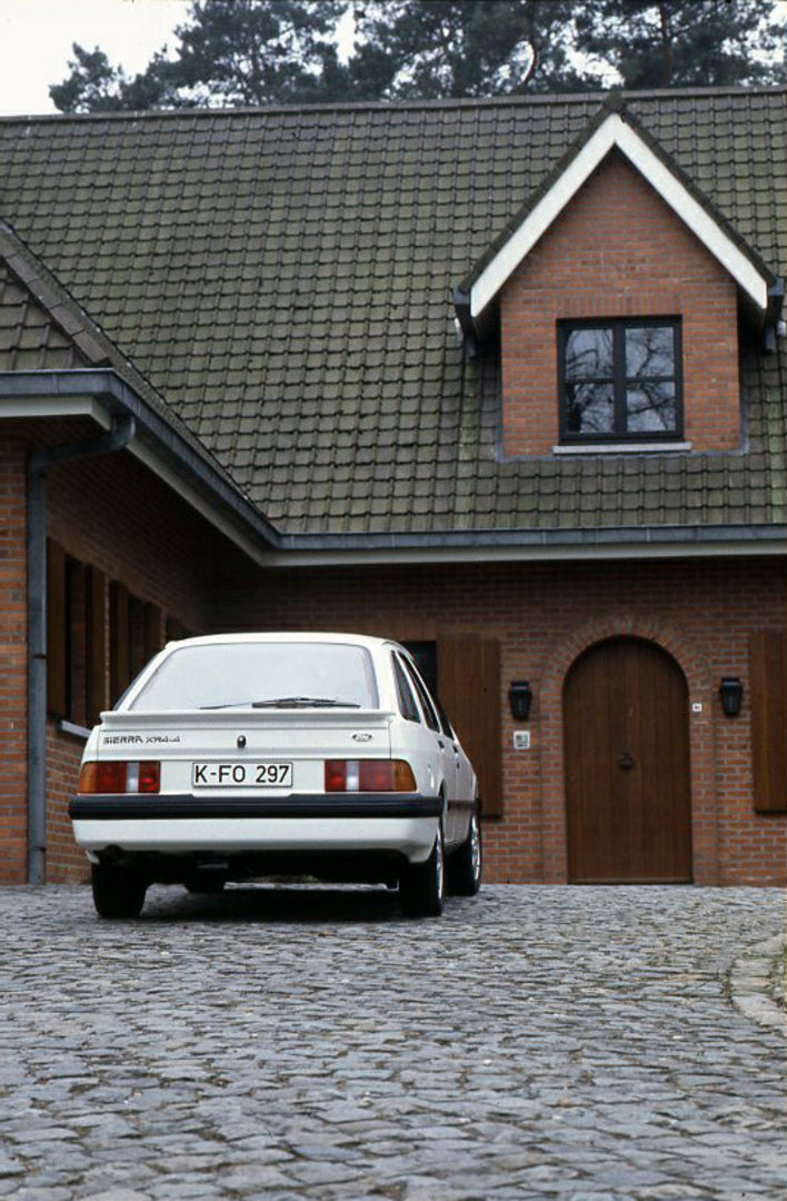 This archival image documents the 1985 Ford Sierra XR 4x4 LHD rear view in driveway vertical shot and is preserved in the Ford Heritage Vault as part of Ford Motor Company's historic photographic archive. Free for personal, non-commercial use. For...