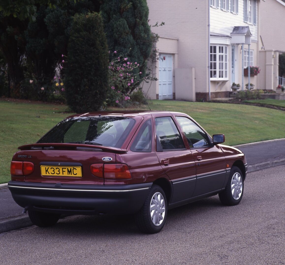 This archival image documents the 1992 Ford Escort Mark V LX rear view on scenic neighborhood street and is preserved in the Ford Heritage Vault as part of Ford Motor Company's historic photographic archive. Free for personal, non-commercial use. ...