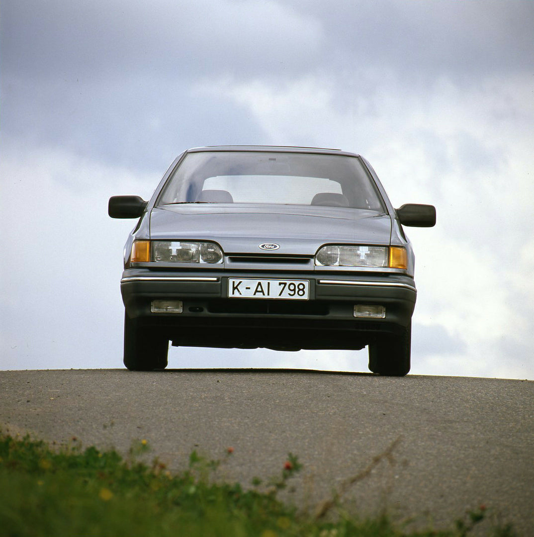 This archival image documents the 1985 Ford Scorpio Mark I Ghia front view on road and is preserved in the Ford Heritage Vault as part of Ford Motor Company's historic photographic archive. Free for personal, non-commercial use. Ford Heritage Vaul...