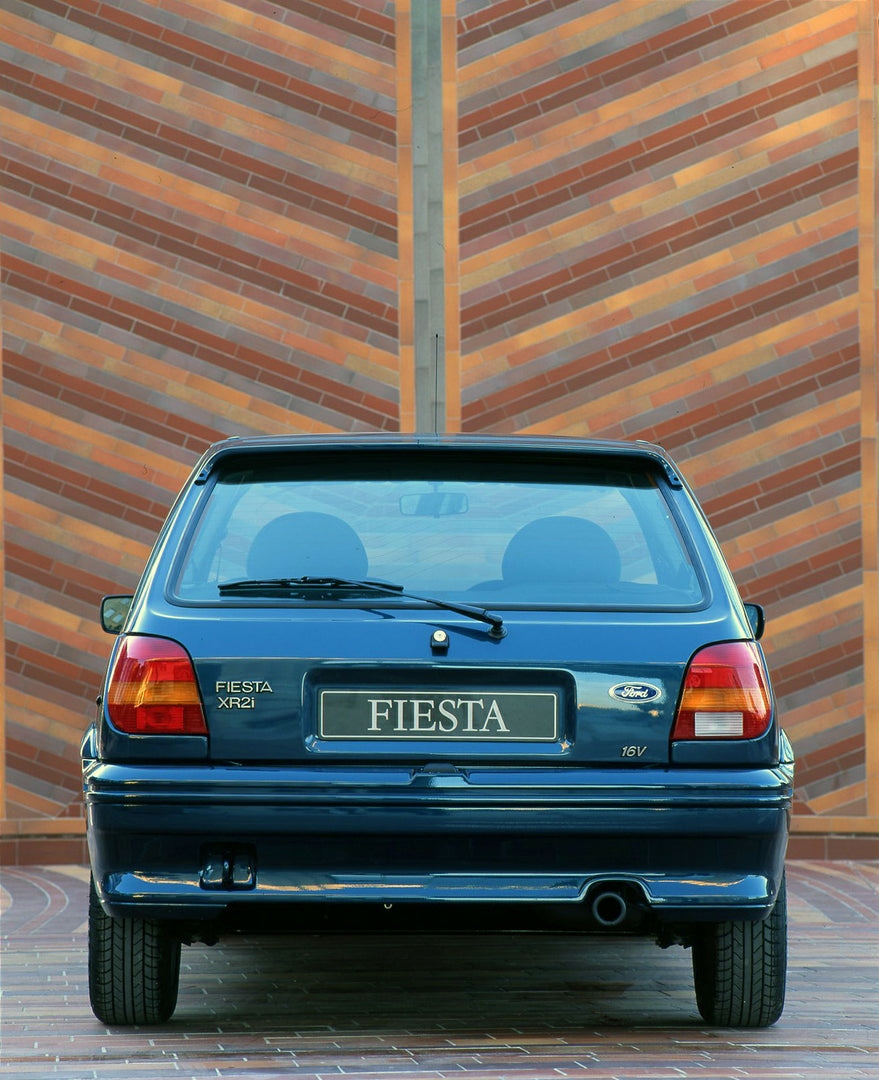 This archival image documents the 1994 1/2 Ford Fiesta Mark III rear view in front of scenic brick mosaic in Cannes and is preserved in the Ford Heritage Vault as part of Ford Motor Company's historic photographic archive. Free for personal, non-c...