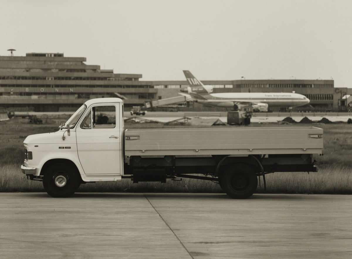 This archival image documents the 1970 Ford A-Series Truck side view with planes in background and is preserved in the Ford Heritage Vault as part of Ford Motor Company's historic photographic archive. Free for personal, non-commercial use. Ford H...