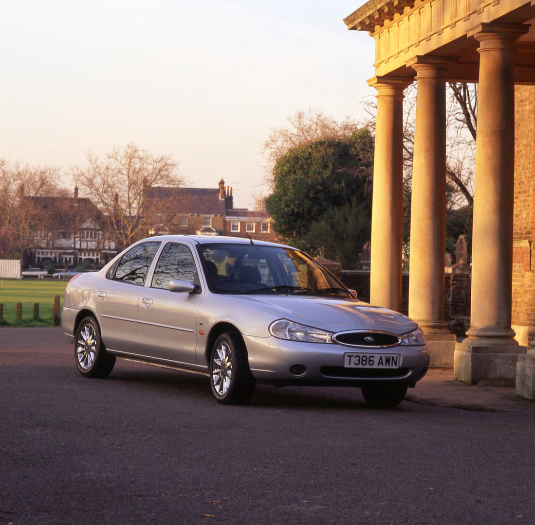 This archival image documents the 1999 Ford Mondeo Mark I Ghia X with scenic houses and building with pillars and is preserved in the Ford Heritage Vault as part of Ford Motor Company's historic photographic archive. Free for personal, non-commerc...