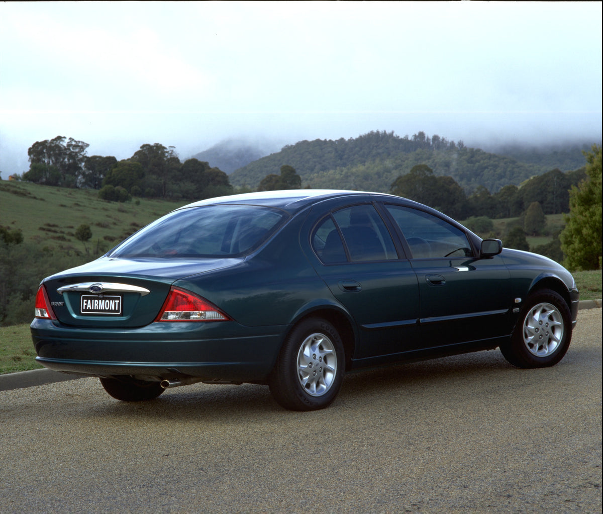 This archival image documents the 1998 Ford Falcon Fairmont rear view on scenic road with trees and is preserved in the Ford Heritage Vault as part of Ford Motor Company's historic photographic archive. Free for personal, non-commercial use. Ford ...
