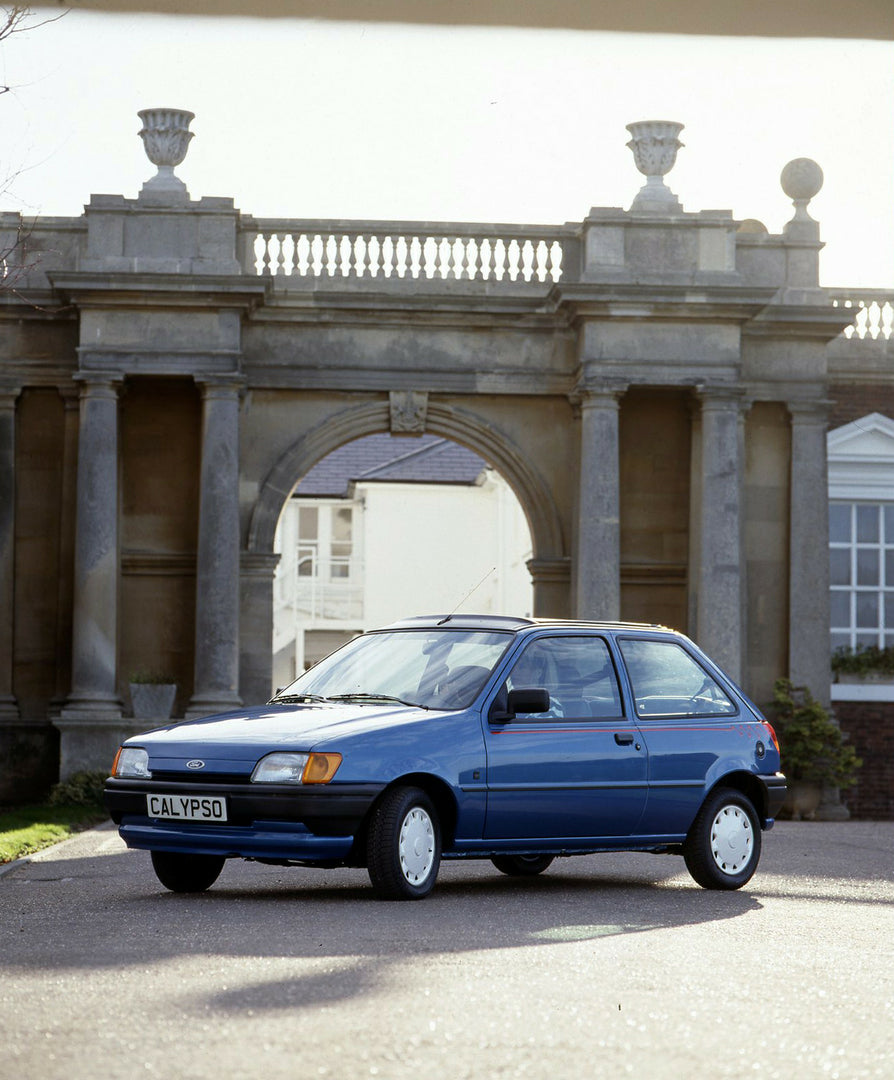 This archival image documents the 1990 Ford Fiesta Calypso LHD with building in background and is preserved in the Ford Heritage Vault as part of Ford Motor Company's historic photographic archive. Free for personal, non-commercial use. Ford Herit...