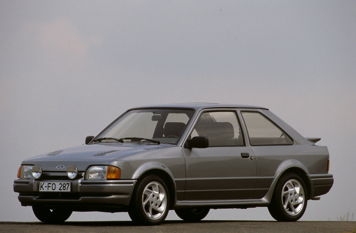 This archival image documents the 1986 Ford Escort Mark IV RS Turbo with scenic blue sky and is preserved in the Ford Heritage Vault as part of Ford Motor Company's historic photographic archive. Free for personal, non-commercial use. Ford Heritag...