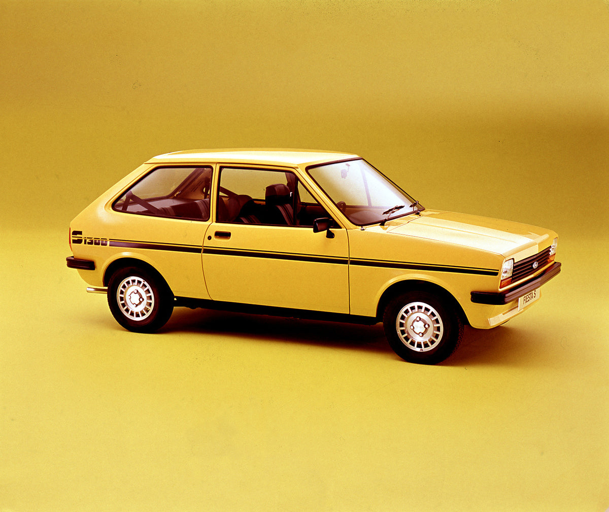 This archival image documents the 1977 Ford Fiesta Mark I 1300 Sport in studio and is preserved in the Ford Heritage Vault as part of Ford Motor Company's historic photographic archive. Free for personal, non-commercial use. Ford Heritage Vault re...