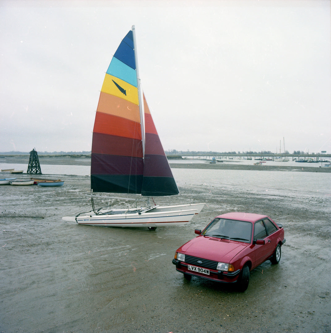 This archival image documents the 1980 Ford Escort Mark III XR3 and Collapsible Boats on scenic beach and is preserved in the Ford Heritage Vault as part of Ford Motor Company's historic photographic archive. Free for personal, non-commercial use....