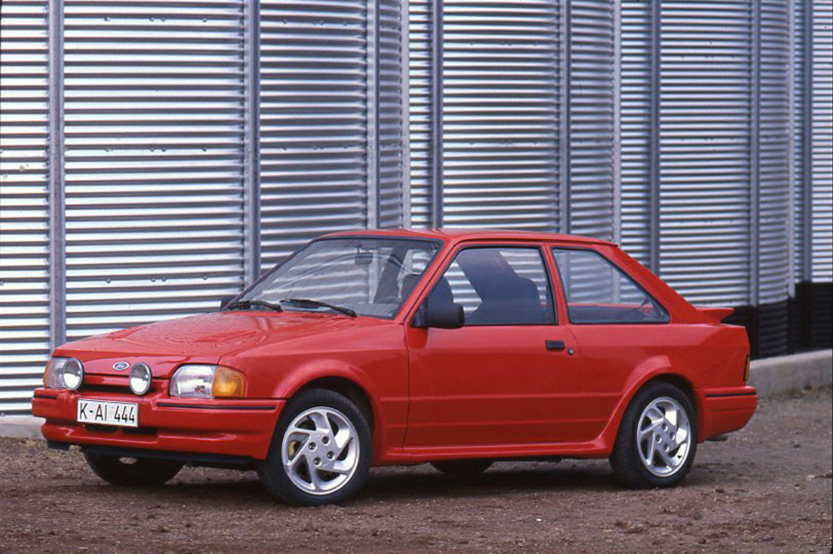 This archival image documents the 1986 Ford Escort Mark IV in front of metal silos and is preserved in the Ford Heritage Vault as part of Ford Motor Company's historic photographic archive. Free for personal, non-commercial use. Ford Heritage Vaul...