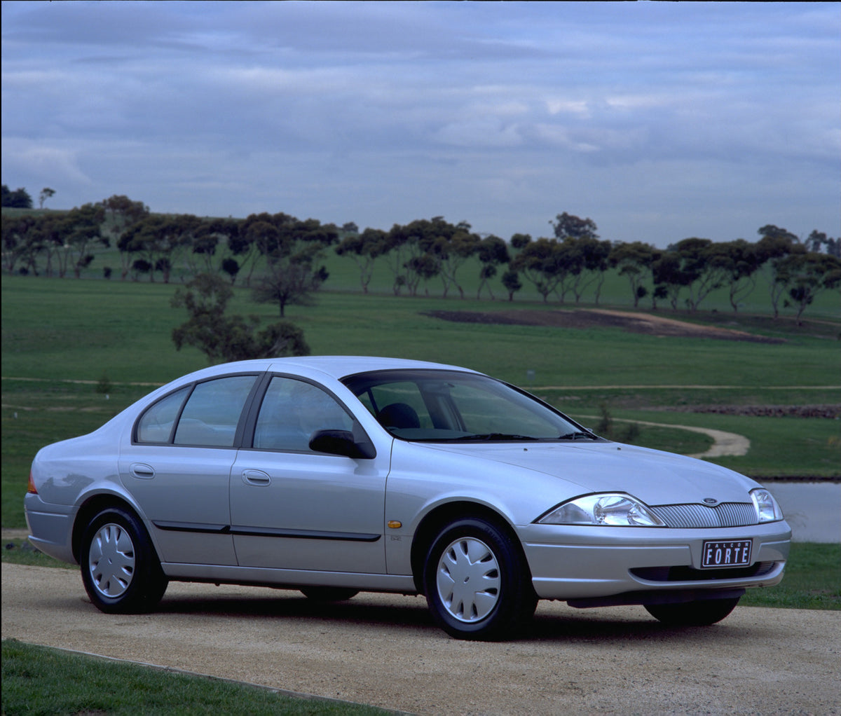 This archival image documents the 1998 Ford Falcon Forte on scenic road with trees and is preserved in the Ford Heritage Vault as part of Ford Motor Company's historic photographic archive. Free for personal, non-commercial use. Ford Heritage Vaul...