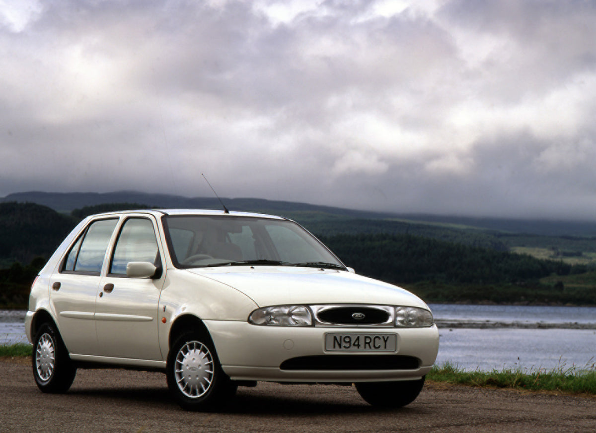 This archival image documents the 1994 Ford Fiesta Mark IV Ghia with scenic hills and water and is preserved in the Ford Heritage Vault as part of Ford Motor Company's historic photographic archive. Free for personal, non-commercial use. Ford Heri...