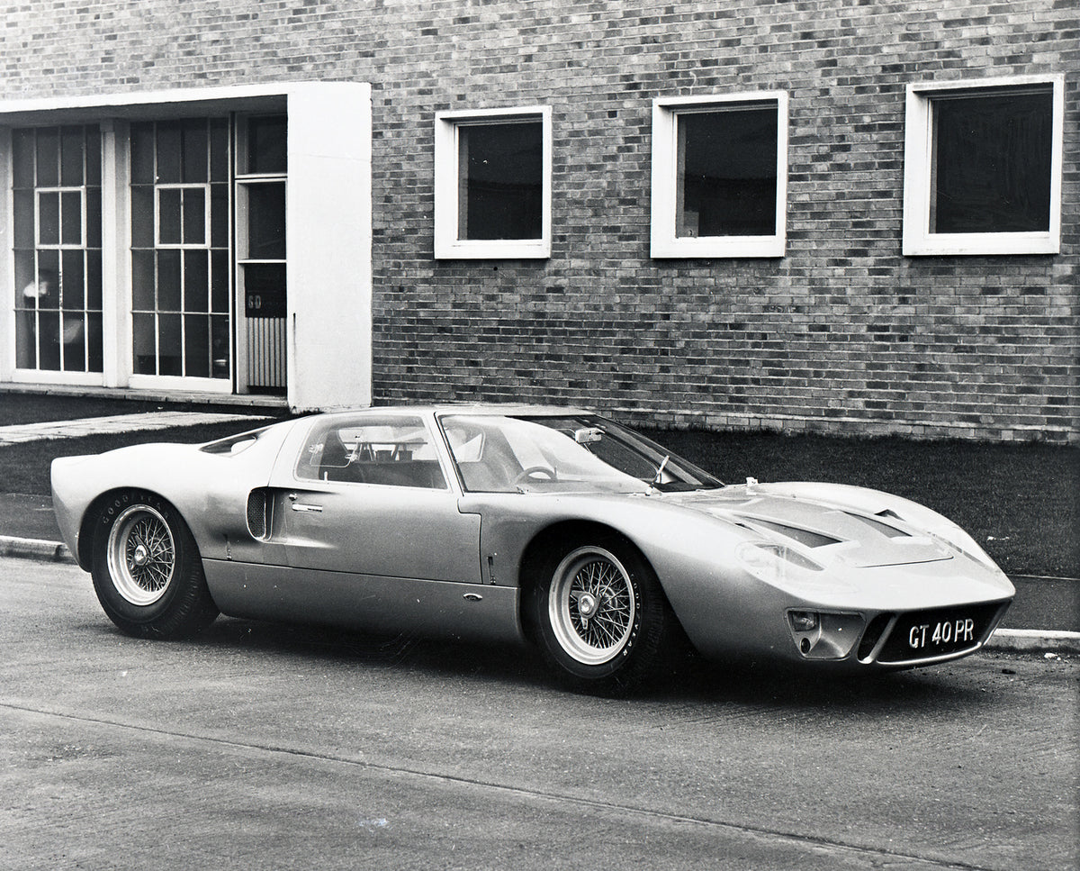 This archival image documents the 1965 Ford GT40 Mark I in front of brick building and is preserved in the Ford Heritage Vault as part of Ford Motor Company's historic photographic archive. Free for personal, non-commercial use. Ford Heritage Vaul...