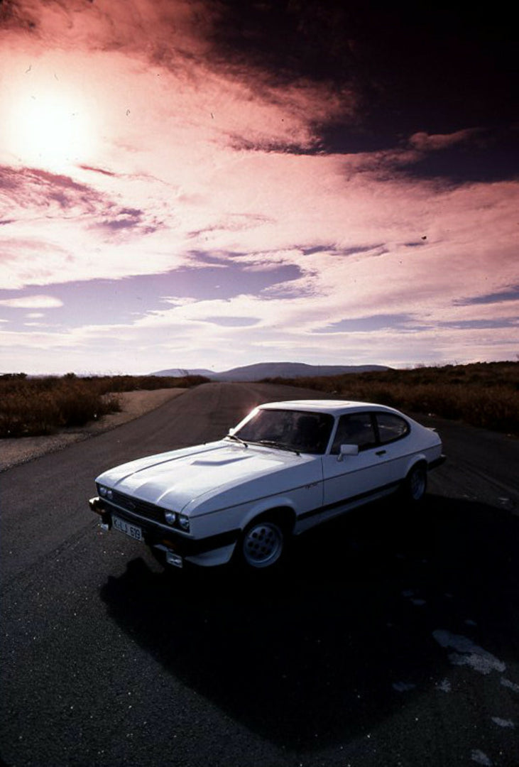 This archival image documents the 1981 Ford Capri Mark III LHD 2.8 Injection on scenic road and is preserved in the Ford Heritage Vault as part of Ford Motor Company's historic photographic archive. Free for personal, non-commercial use. Ford Heri...