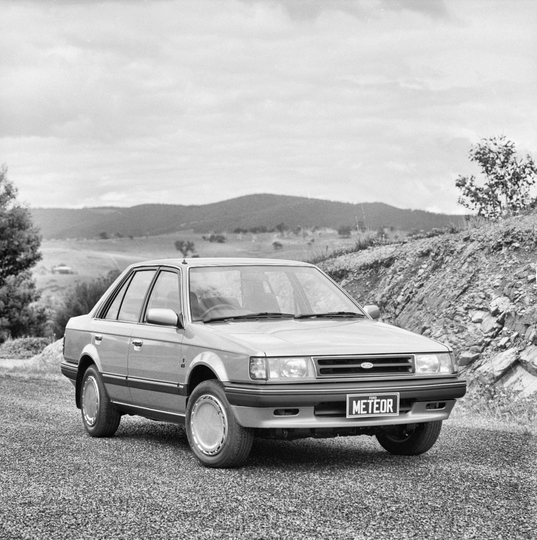 This archival image documents the 1985 Ford GA Meteor Sedan Driver Side Front End View on Country Road FAP-2011-3 and is preserved in the Ford Heritage Vault as part of Ford Motor Company's historic photographic archive. Free for personal, non-com...
