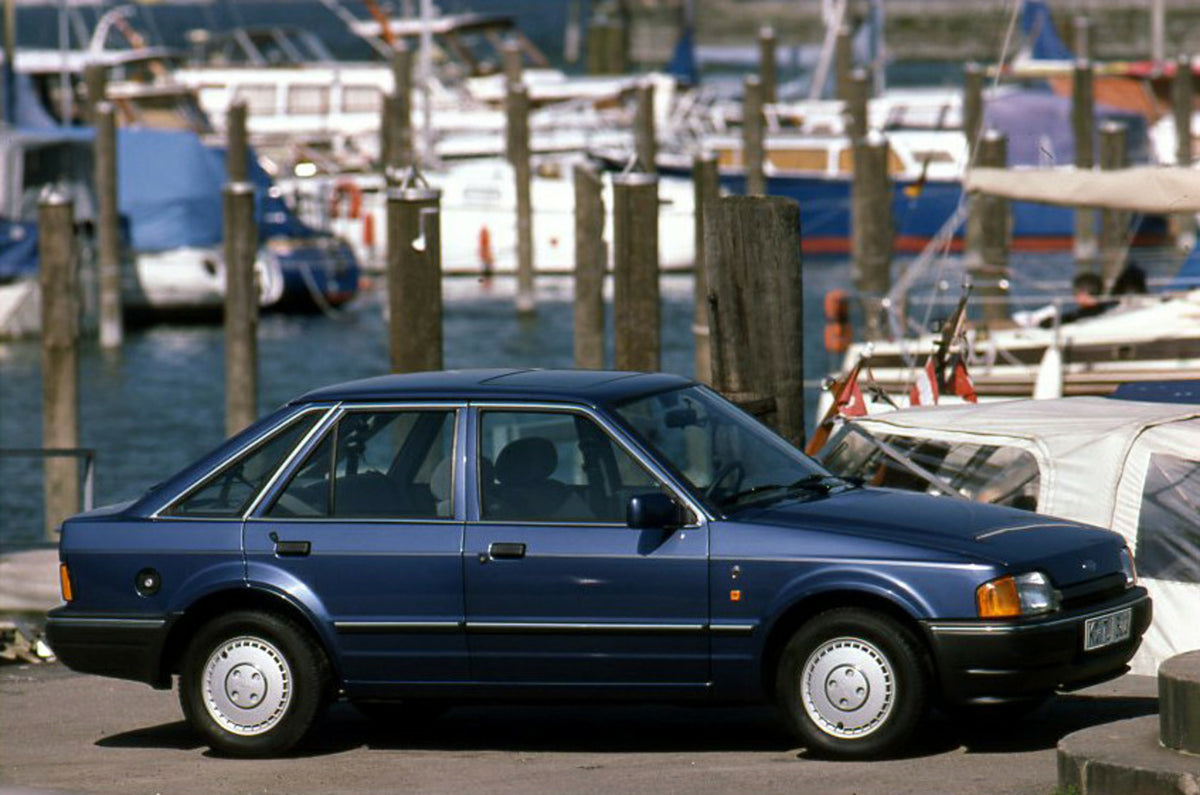 This archival image documents the 1989 Ford Escort Mark IV LHD side view in scenic harbor and is preserved in the Ford Heritage Vault as part of Ford Motor Company's historic photographic archive. Free for personal, non-commercial use. Ford Herita...