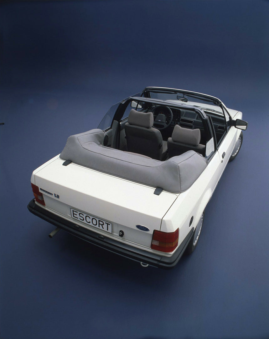 This archival image documents the 1983 Ford Escort Mark III Cabriolet 1.3 GL rear aerial view with top down in studio and is preserved in the Ford Heritage Vault as part of Ford Motor Company's historic photographic archive. Free for personal, non...