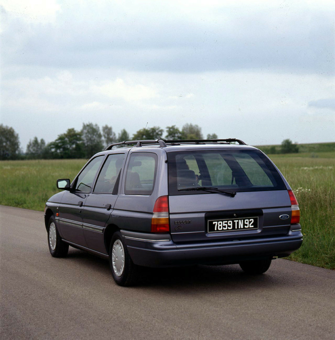 This archival image documents the 1990 Ford Escort Mark IV Estate rear view on scenic road and is preserved in the Ford Heritage Vault as part of Ford Motor Company's historic photographic archive. Free for personal, non-commercial use. Ford Herit...