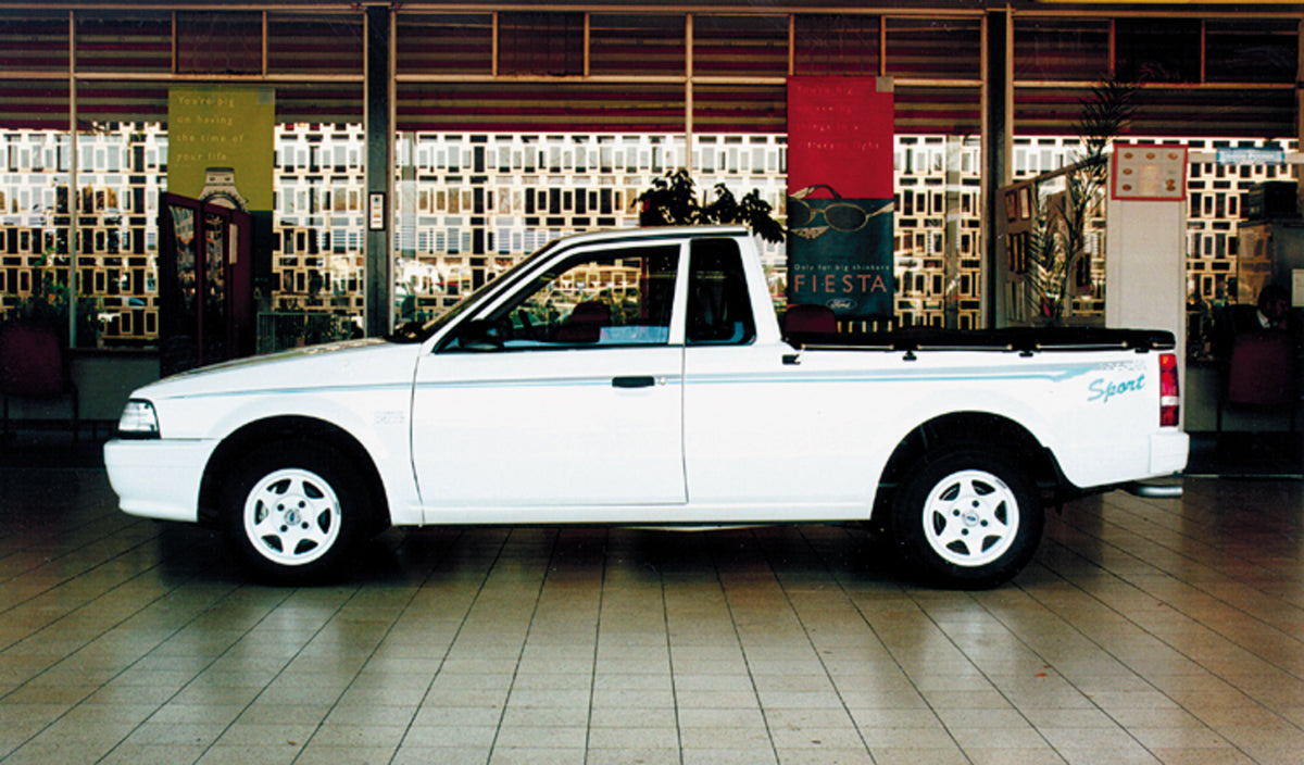 This archival image documents the 1999 Ford Bantam side view inside shopping mall and is preserved in the Ford Heritage Vault as part of Ford Motor Company's historic photographic archive. Free for personal, non-commercial use. Ford Heritage Vault...