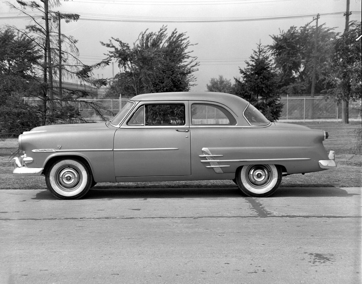 This archival image documents the 1953 Meteor Customline Coupe side view on scenic road AR-2007-5 and is preserved in the Ford Heritage Vault as part of Ford Motor Company's historic photographic archive. Free for personal, non-commercial use. For...
