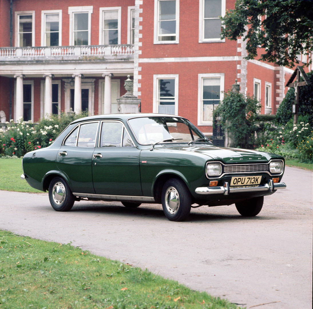 This archival image documents the 1971 Ford Escort Mark I in driveway of scenic house and is preserved in the Ford Heritage Vault as part of Ford Motor Company's historic photographic archive. Free for personal, non-commercial use. Ford Heritage V...