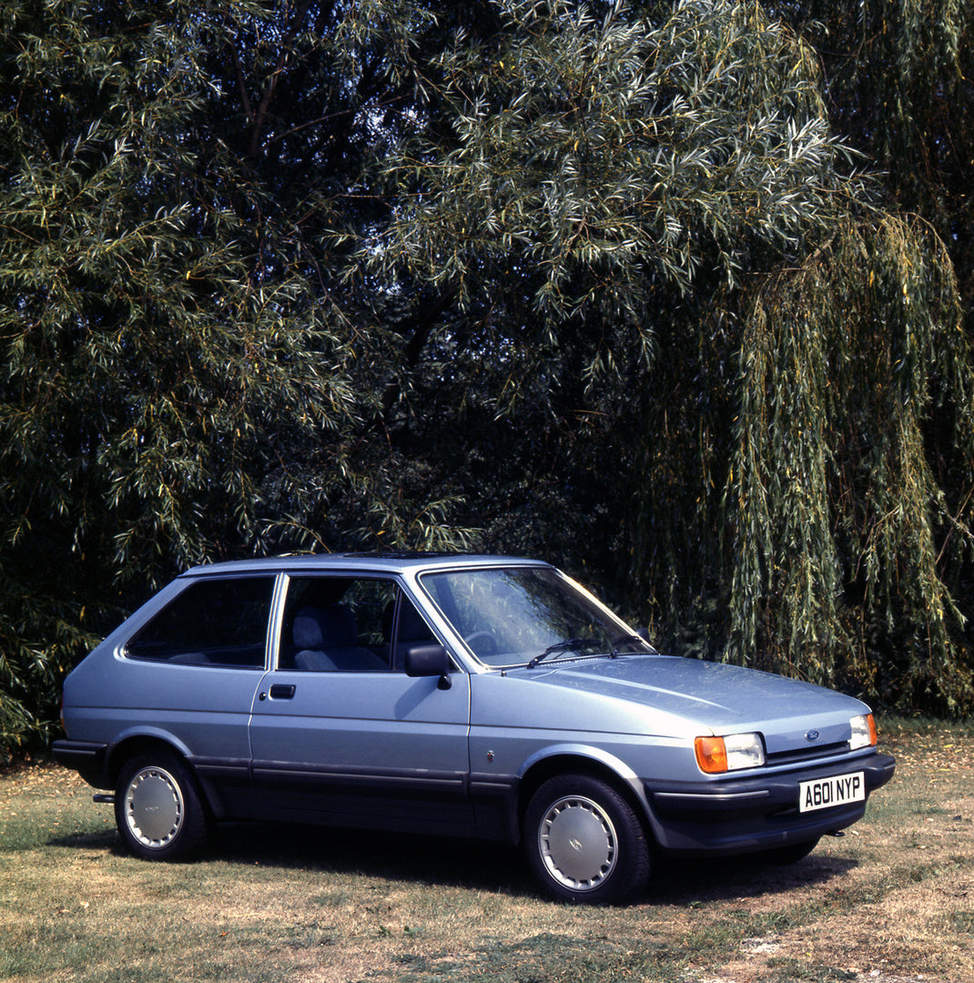 This archival image documents the 1983 Ford Fiesta Mark II Ghia in front of scenic trees and is preserved in the Ford Heritage Vault as part of Ford Motor Company's historic photographic archive. Free for personal, non-commercial use. Ford Heritag...