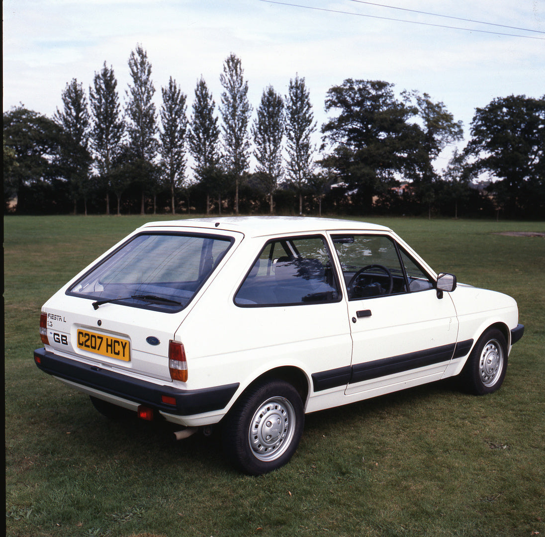 This archival image documents the 1985 Ford Fiesta Mark II 1.3 L rear view in scenic field with trees and is preserved in the Ford Heritage Vault as part of Ford Motor Company's historic photographic archive. Free for personal, non-commercial use....