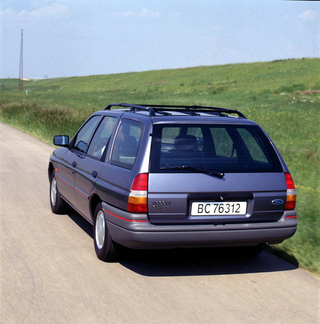 This archival image documents the 1990 Ford Escort Mark IV Estate rear view action shot on scenic road and is preserved in the Ford Heritage Vault as part of Ford Motor Company's historic photographic archive. Free for personal, non-commercial use...