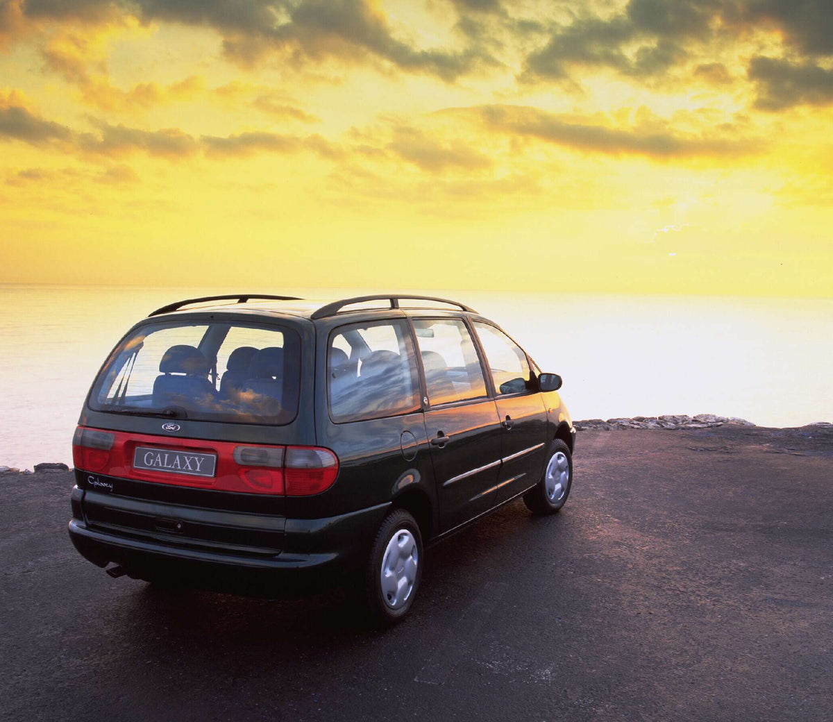 This archival image documents the 1994 Ford Galaxy Mark I GLX rear view with scenic sunset sky AR-2002-213709 and is preserved in the Ford Heritage Vault as part of Ford Motor Company's historic photographic archive. Free for personal, non-commerc...