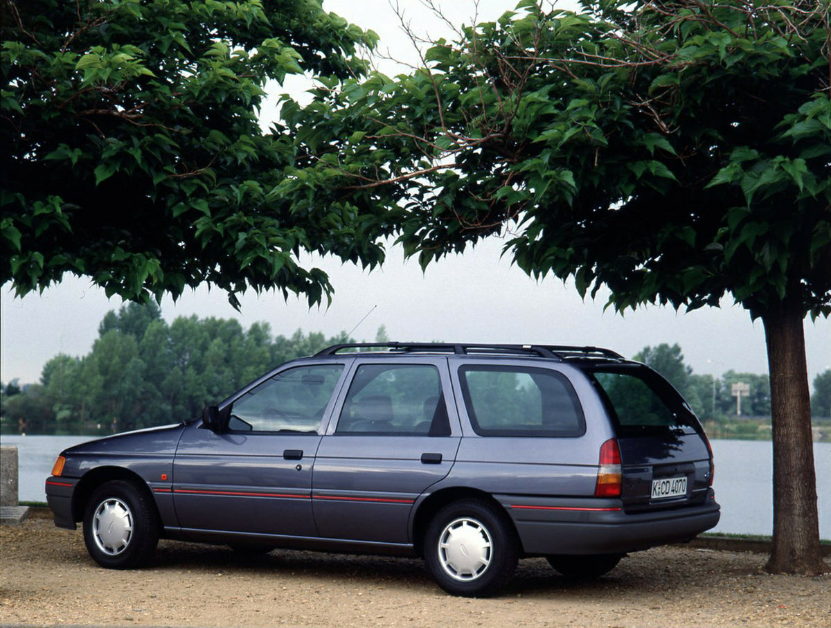 This archival image documents the 1990 Ford Escort Mark IV Estate rear view with scenic trees and is preserved in the Ford Heritage Vault as part of Ford Motor Company's historic photographic archive. Free for personal, non-commercial use. Ford He...