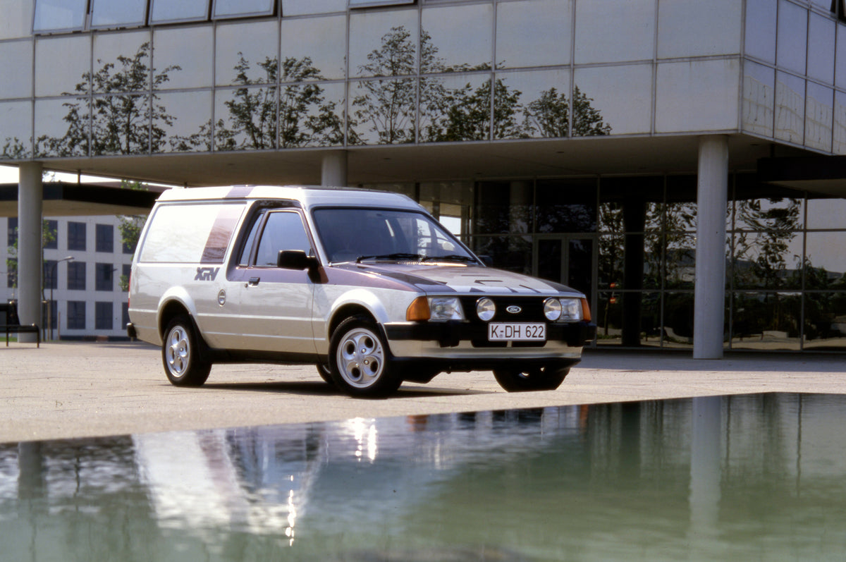 This archival image documents the 1981 Ford Escort Mark III Van XRV in front of scenic glass building 1981-853 1 and is preserved in the Ford Heritage Vault as part of Ford Motor Company's historic photographic archive. Free for personal, non-comm...
