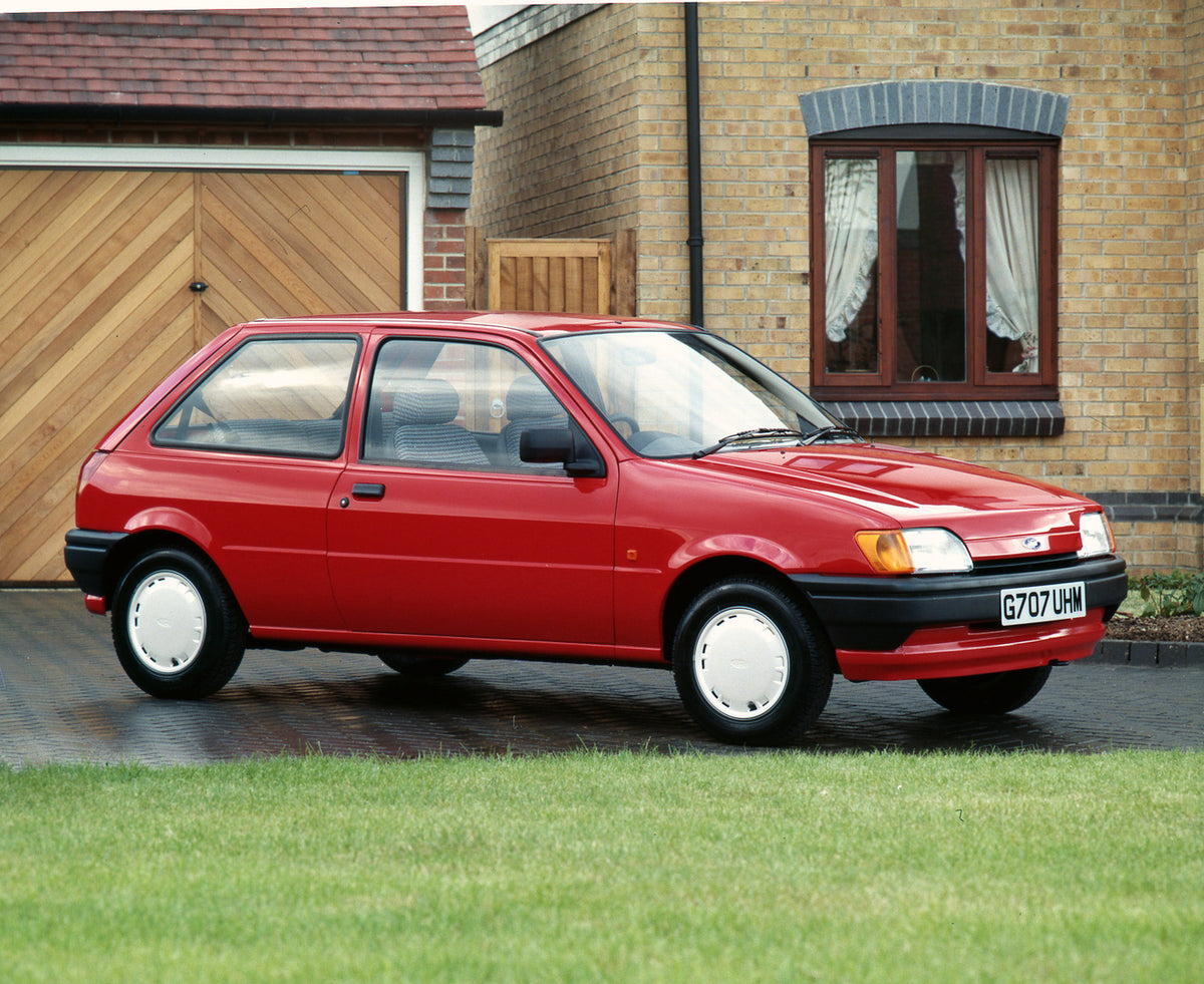 This archival image documents the 1990 Ford Fiesta Mark III Bonus in front of house and is preserved in the Ford Heritage Vault as part of Ford Motor Company's historic photographic archive. Free for personal, non-commercial use. Ford Heritage Vau...