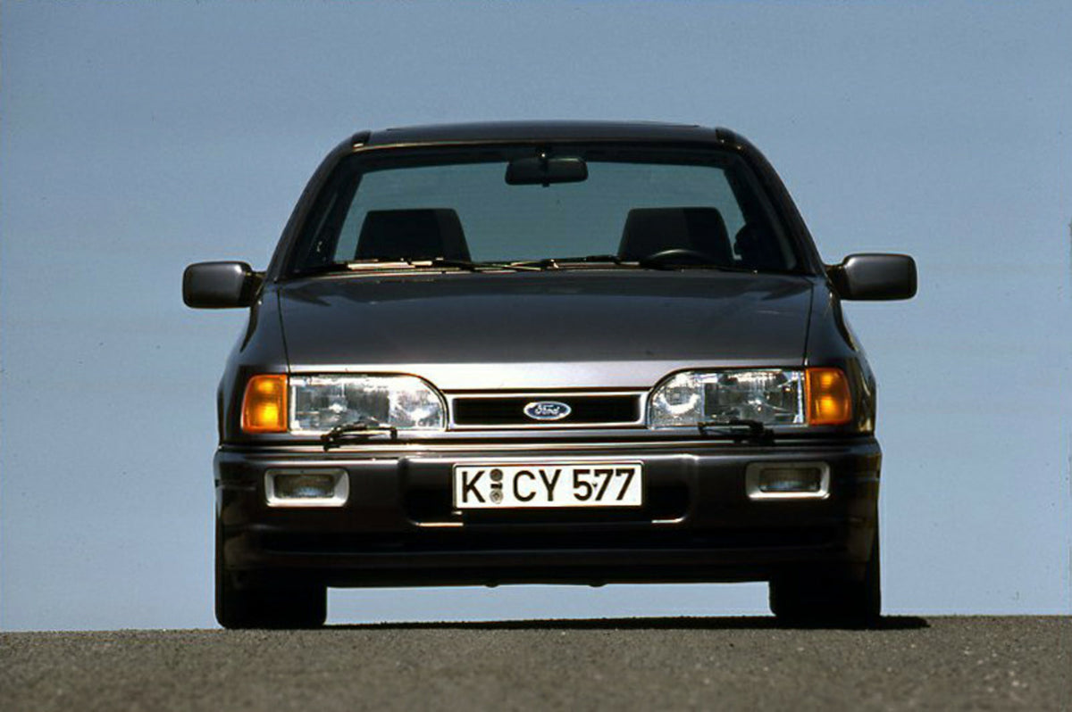 This archival image documents the 1987 Ford Sierra RS Cosworth front view with scenic blue sky and is preserved in the Ford Heritage Vault as part of Ford Motor Company's historic photographic archive. Free for personal, non-commercial use. Ford H...