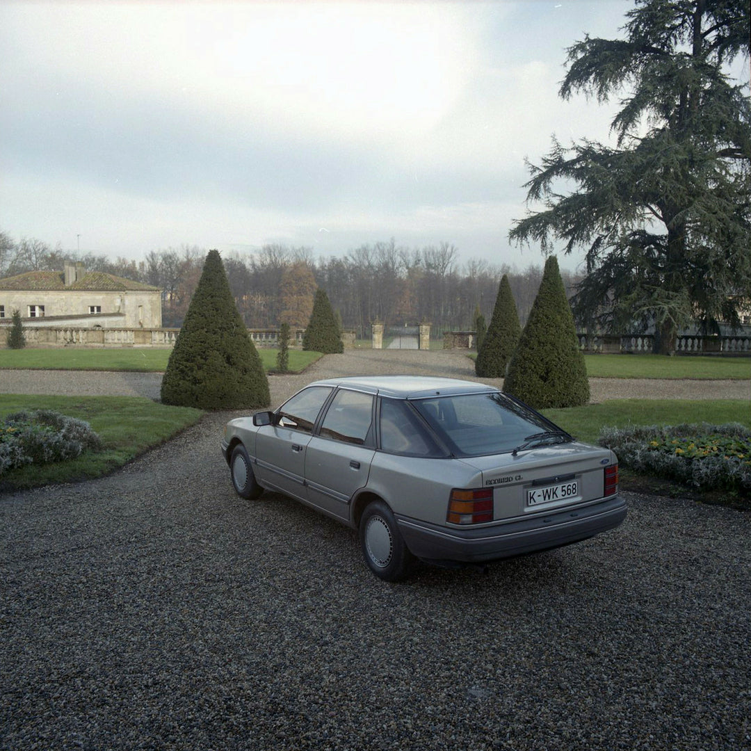 This archival image documents the 1984 Ford Scorpio Mark I LHD rear view in scenic driveway with trees in Bordeaux and is preserved in the Ford Heritage Vault as part of Ford Motor Company's historic photographic archive. Free for personal, non-co...