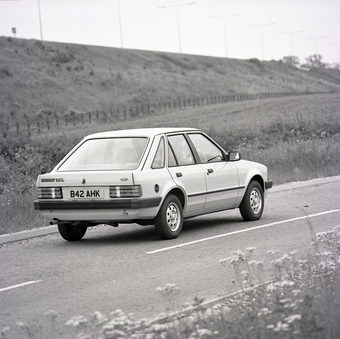This archival image documents the 1985 Ford Escort Mark III XR3i rear view on scenic road and is preserved in the Ford Heritage Vault as part of Ford Motor Company's historic photographic archive. Free for personal, non-commercial use. Ford Herita...