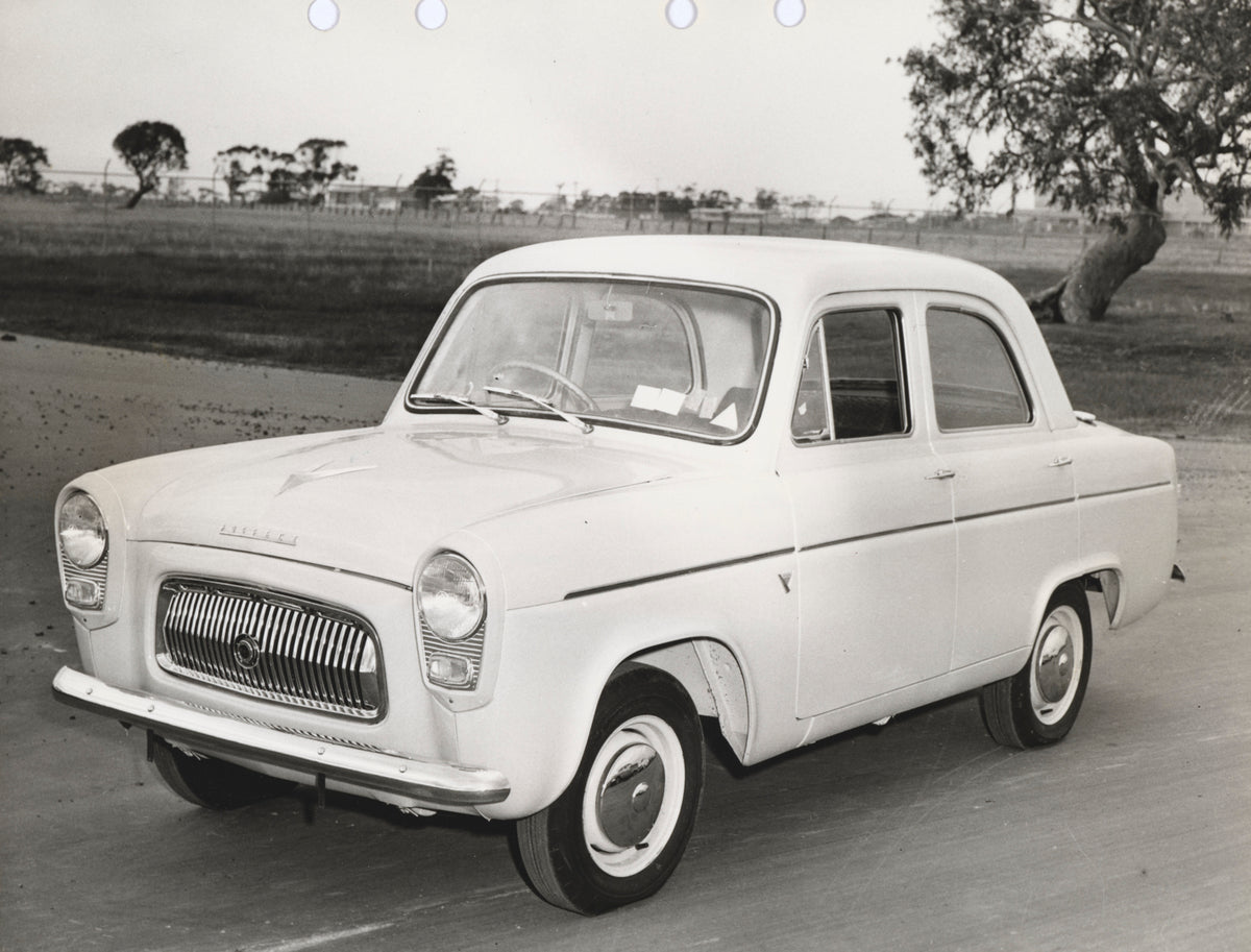 This archival image documents the 1955 Ford Prefect Sedan Passenger Side Front End View on Country Road FAP-2011-3 and is preserved in the Ford Heritage Vault as part of Ford Motor Company's historic photographic archive. Free for personal, non-co...