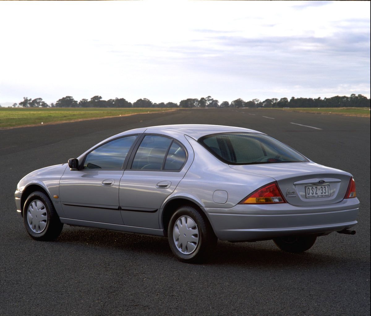 This archival image documents the 1998 Ford Falcon Forte rear view on scenic road with trees and is preserved in the Ford Heritage Vault as part of Ford Motor Company's historic photographic archive. Free for personal, non-commercial use. Ford Her...