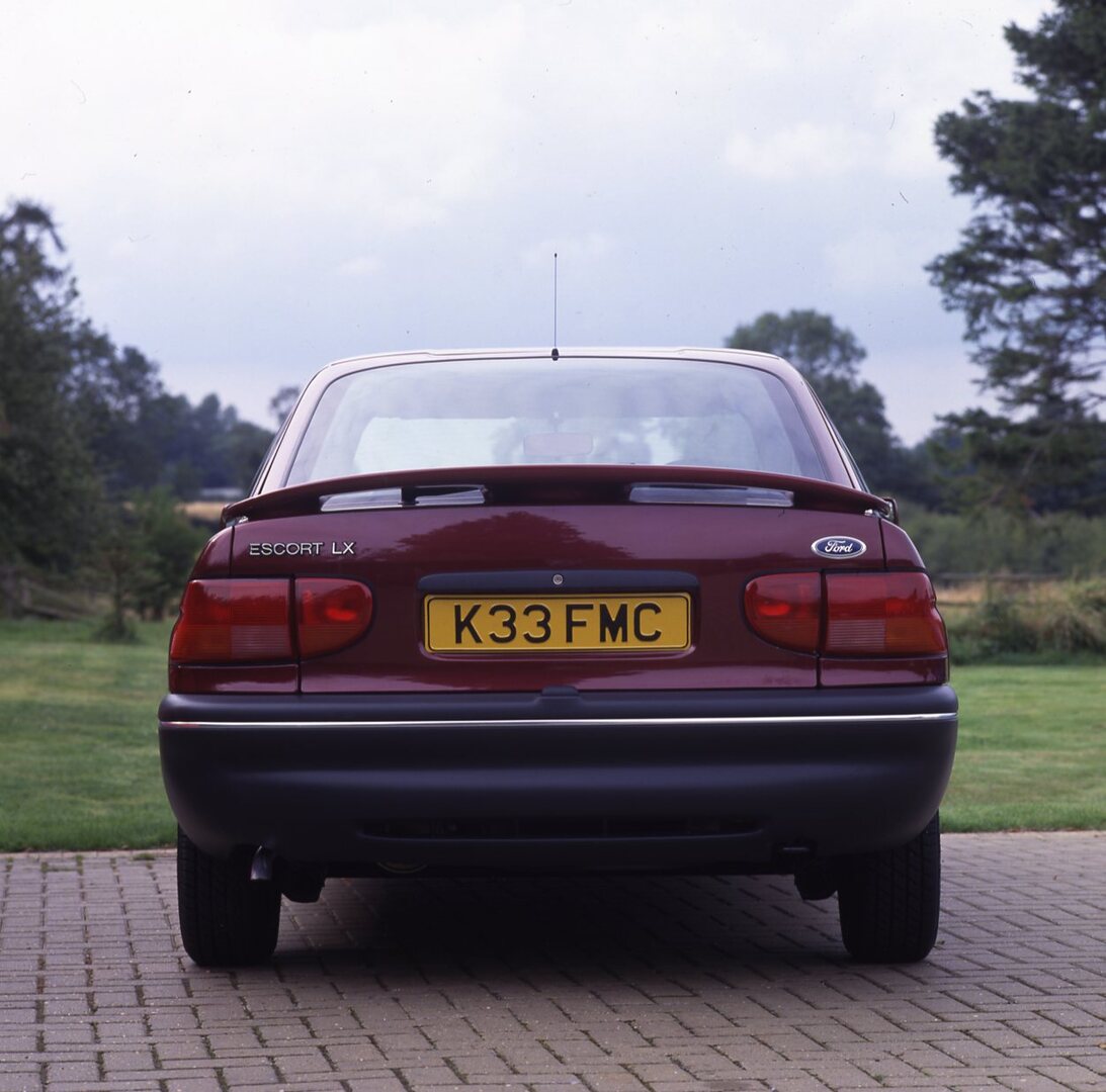 This archival image documents the 1992 Ford Escort Mark V LX rear view closeup with scenic trees and is preserved in the Ford Heritage Vault as part of Ford Motor Company's historic photographic archive. Free for personal, non-commercial use. Ford...