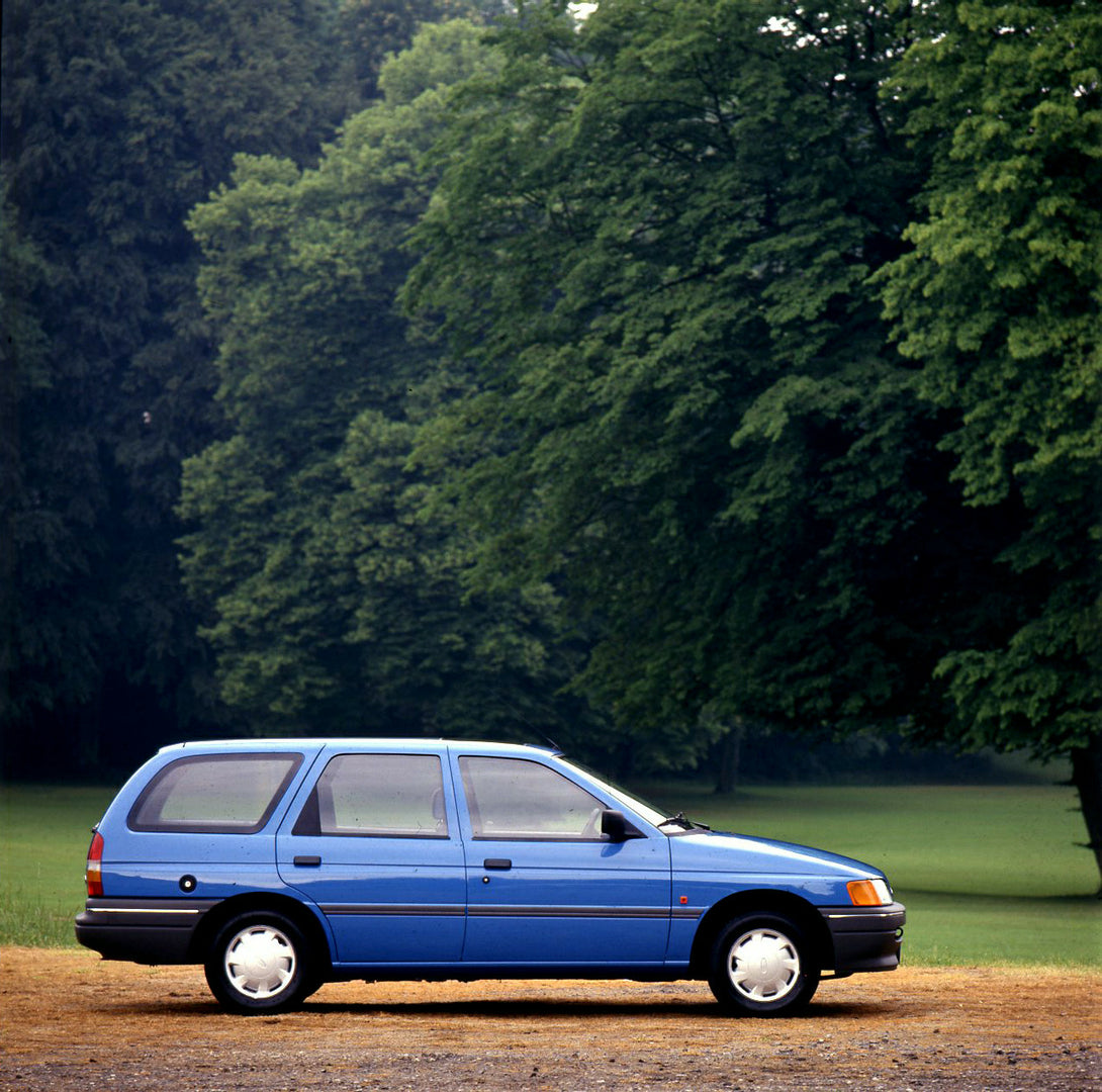 This archival image documents the 1990 Ford Escort Mark IV Estate side view near scenic trees and is preserved in the Ford Heritage Vault as part of Ford Motor Company's historic photographic archive. Free for personal, non-commercial use. Ford He...