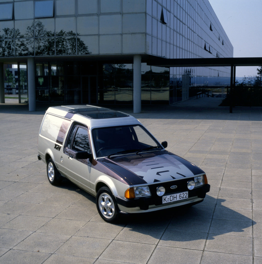 This archival image documents the 1981 Ford Escort Mark III Van XRV in front of scenic glass building 1981-853 2 and is preserved in the Ford Heritage Vault as part of Ford Motor Company's historic photographic archive. Free for personal, non-comm...