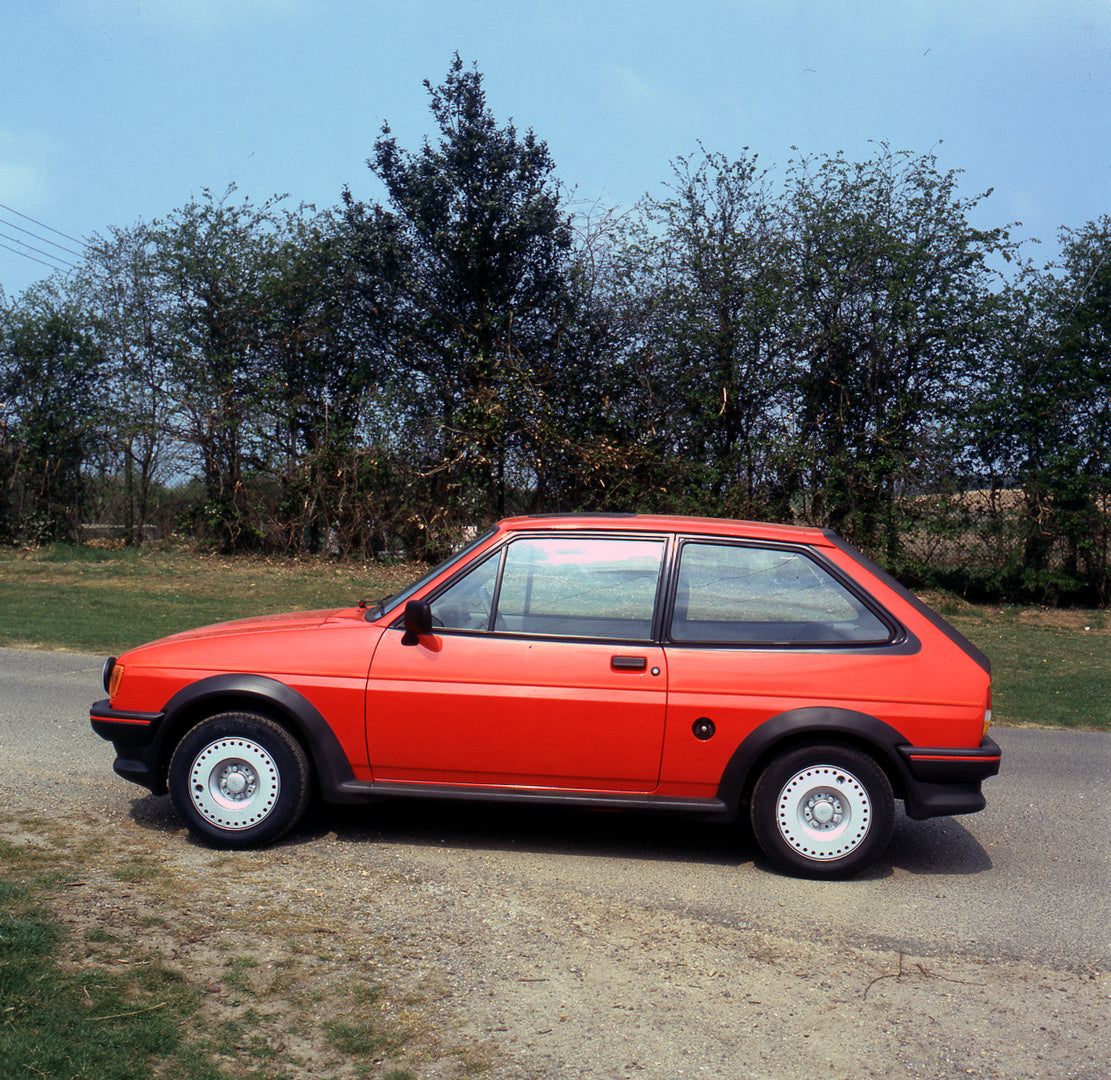 This archival image documents the 1984 Ford Fiesta Mark II XR2 side view on scenic road with trees at Boreham and is preserved in the Ford Heritage Vault as part of Ford Motor Company's historic photographic archive. Free for personal, non-commerc...
