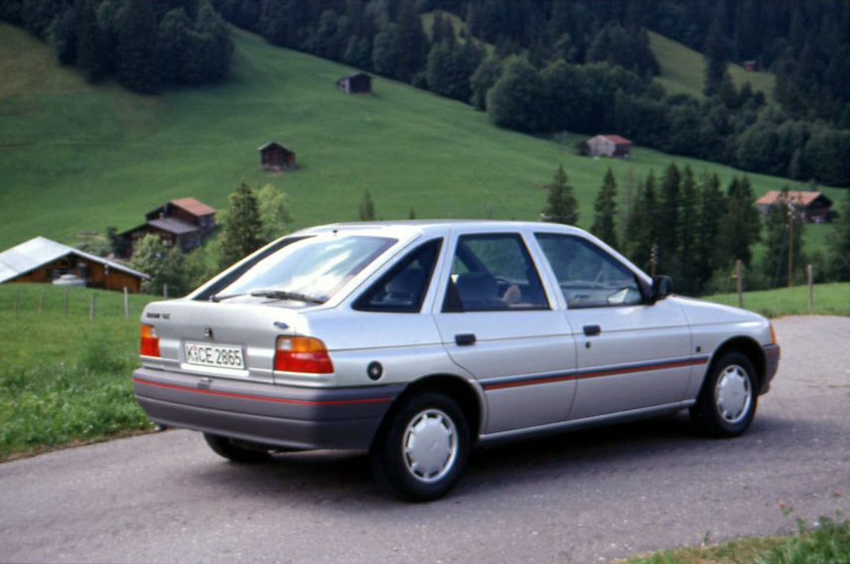This archival image documents the 1990 Ford Escort GLX Mark IV on scenic road in Geneva, Switzerland and is preserved in the Ford Heritage Vault as part of Ford Motor Company's historic photographic archive. Free for personal, non-commercial use. ...