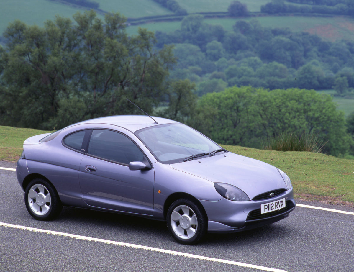 This archival image documents the 1997 Ford Puma on scenic road with trees and is preserved in the Ford Heritage Vault as part of Ford Motor Company's historic photographic archive. Free for personal, non-commercial use. Ford Heritage Vault refere...